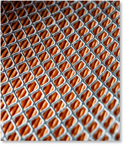 Zbliżenie na teksturowaną powierzchnię z powtarzającym się wzorem siatki w kształcie rombów, przypominającym regały magazynowe, z pomarańczowymi sekcjami otoczonymi metalicznymi liniami, nadającymi geometryczny i abstrakcyjny wygląd.